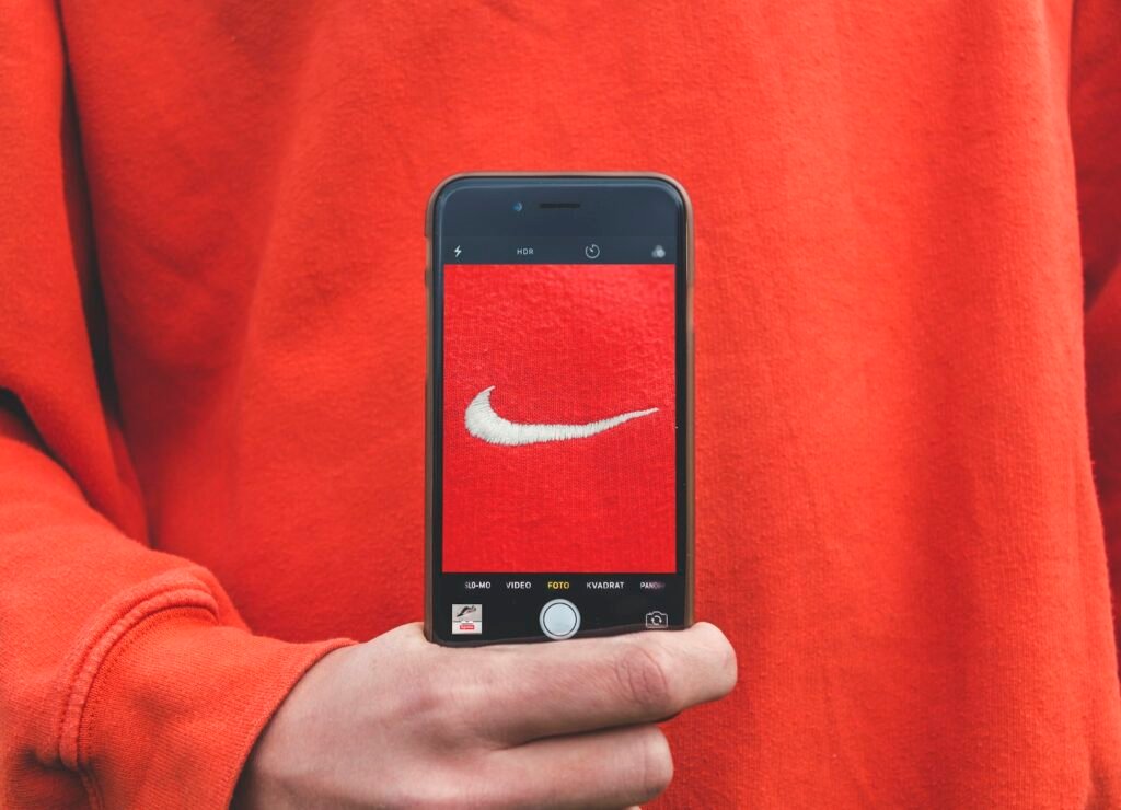 Person photographing a recognizable brand label, representing brand identity signals