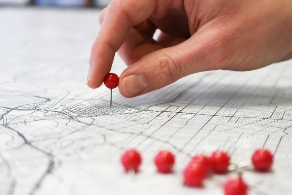 Person placing a red pin on a city map, representing the cost of ignoring local SEO