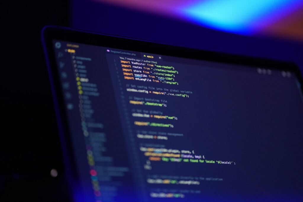 Laptop screen displaying colorful JavaScript code representing destructuring and spread syntax