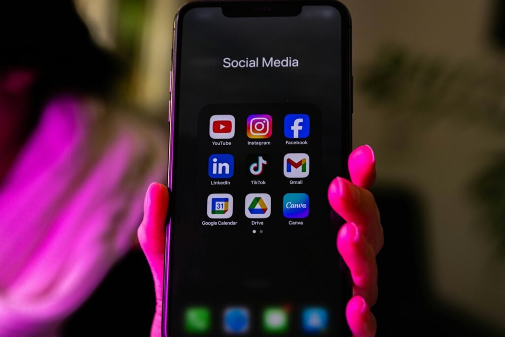 Smartphone displaying a folder of social media app icons including YouTube and TikTok