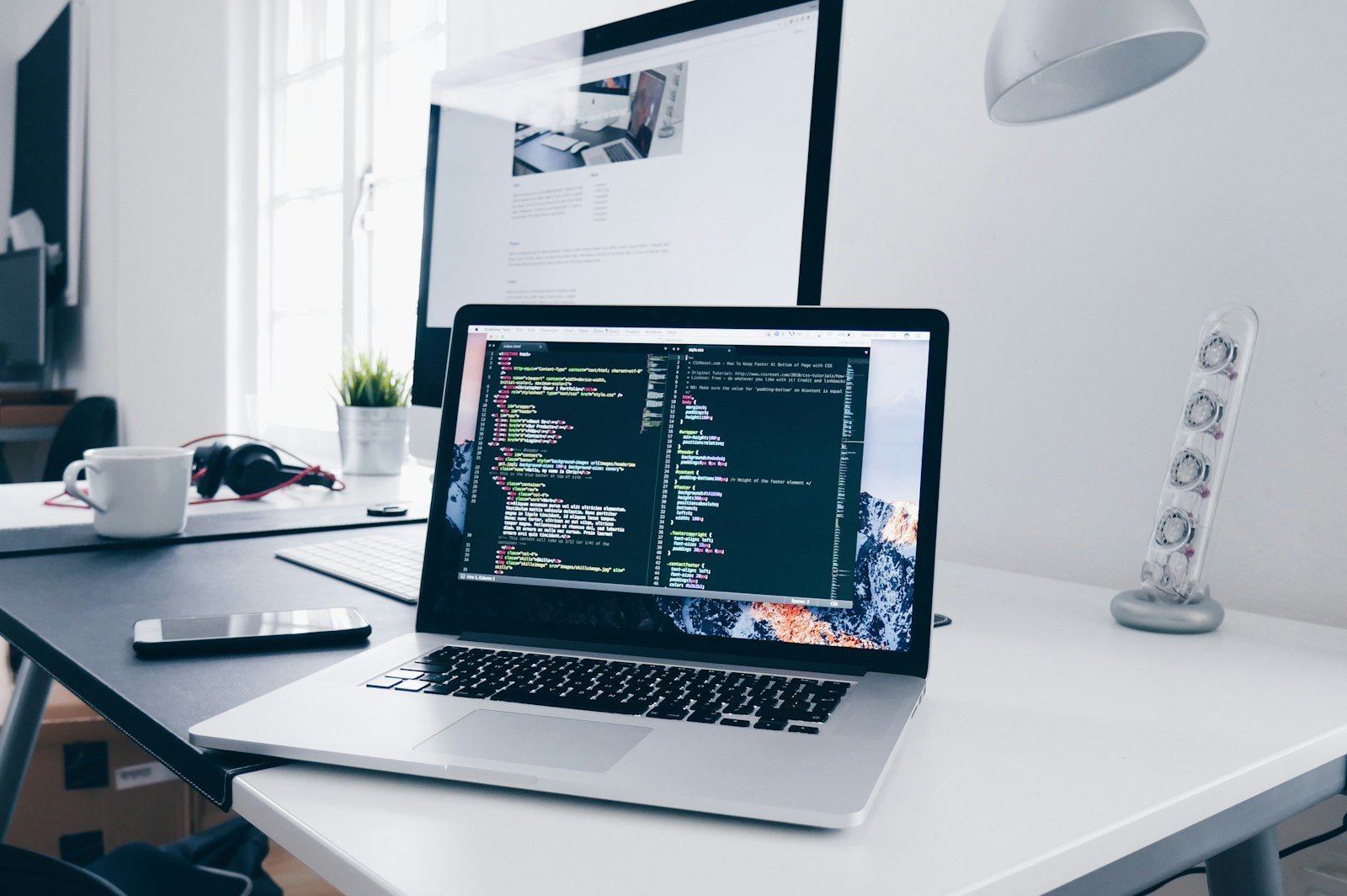MacBook displaying lines of code representing the React JavaScript library