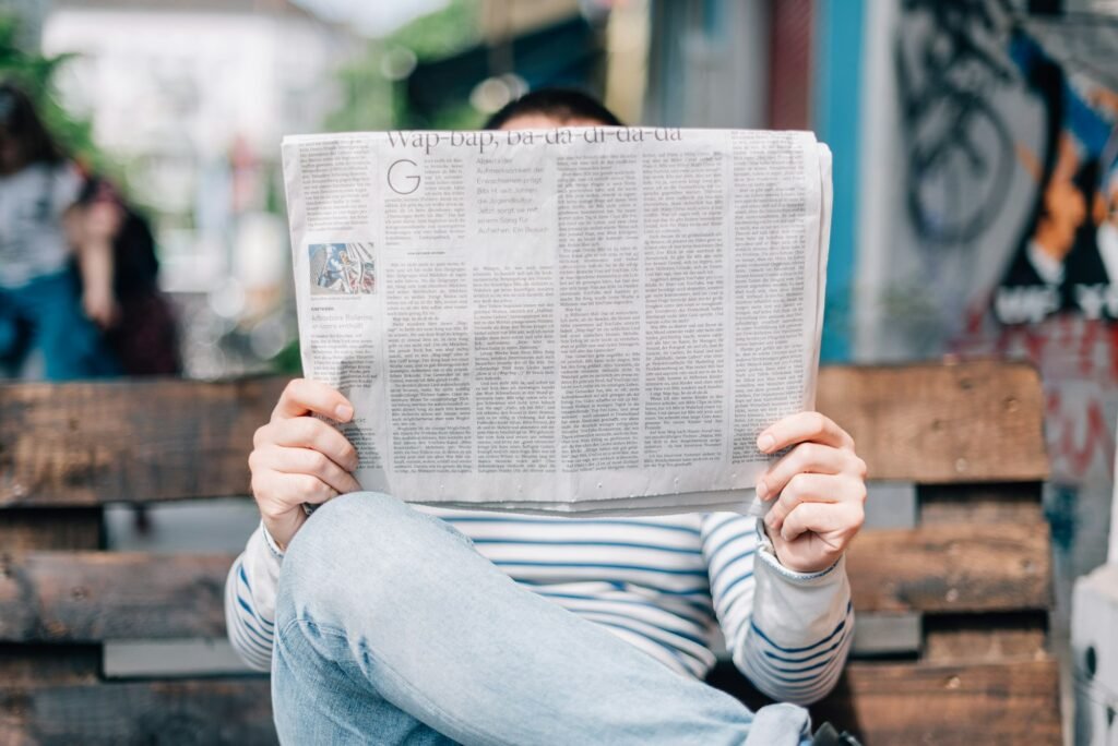 Person reading a newspaper, representing news editing and copyediting services for newsrooms and content teams