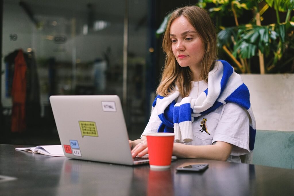 Freelance web developer working on a laptop in a cafe, representing a freelance SEO consultant