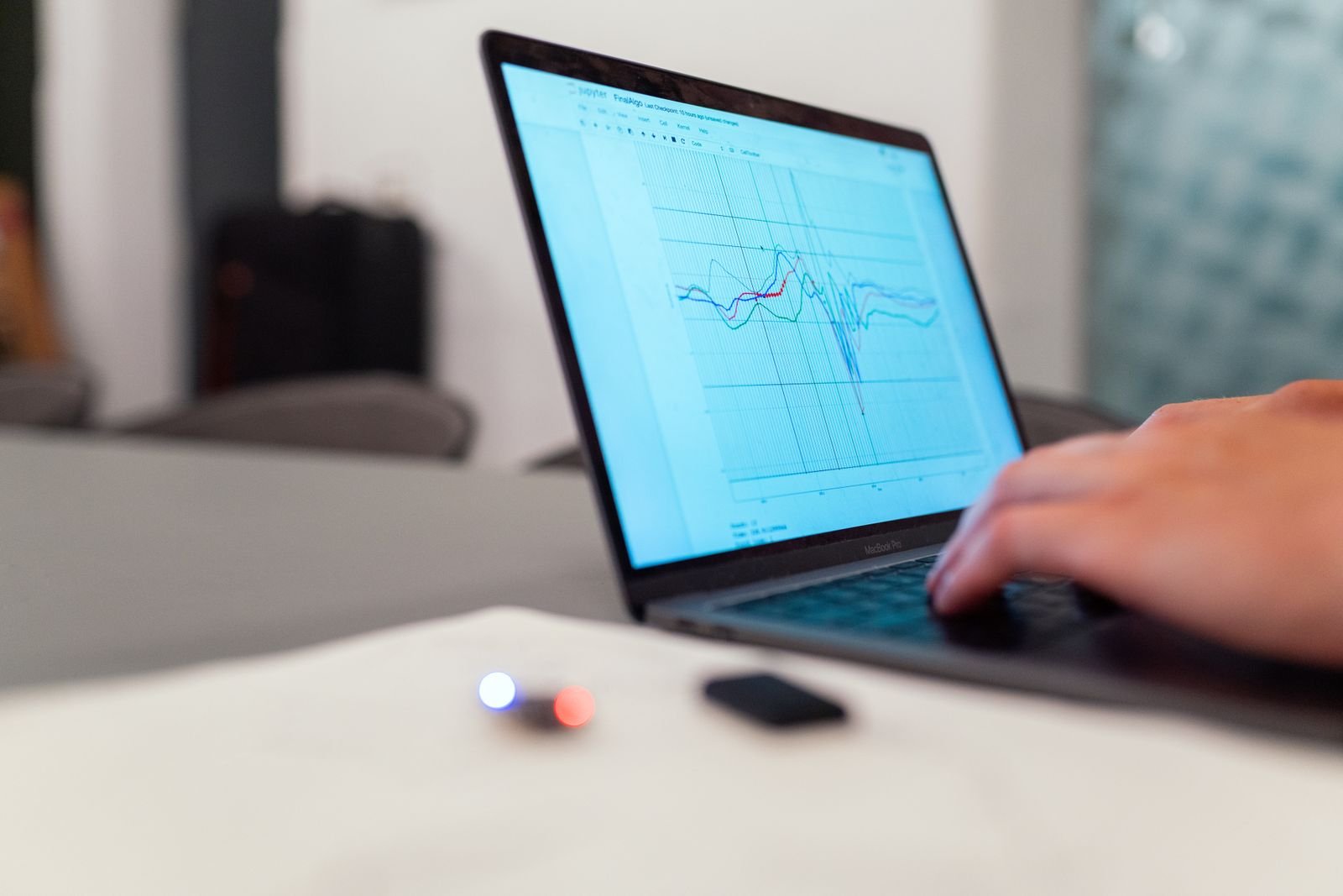 Close-up of a hand on a laptop reviewing a line graph, representing SEO KPI analysis