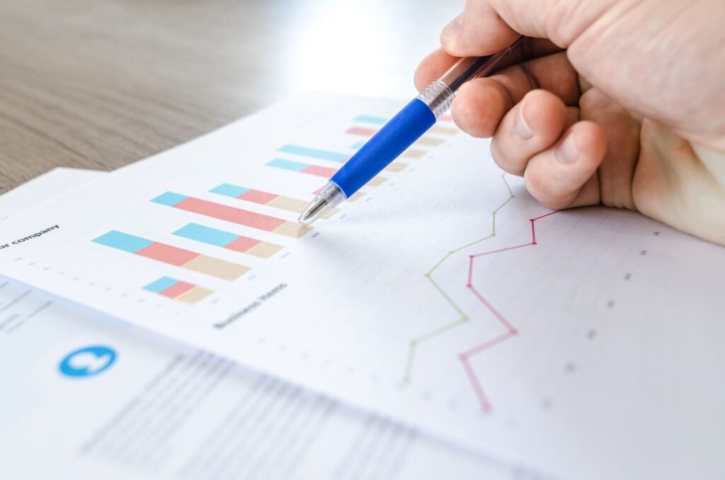 Hand analyzing colorful keyword ranking charts and graphs on paper
